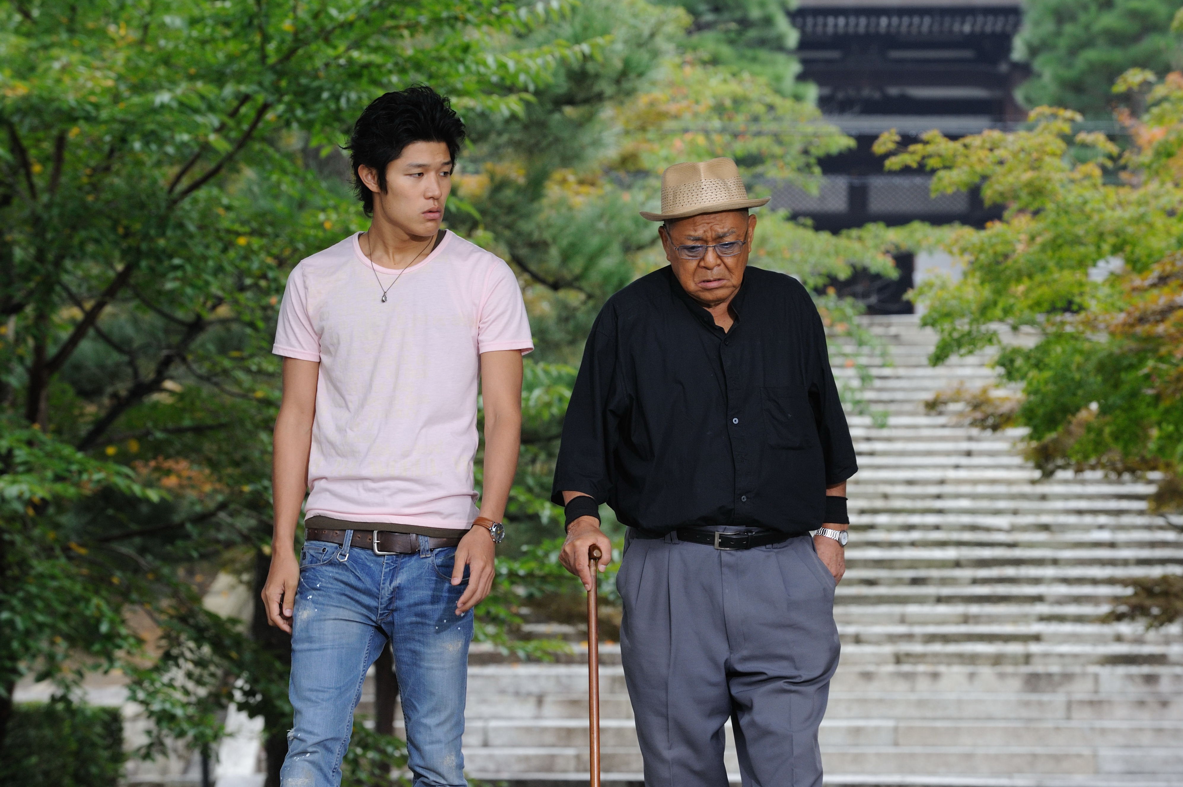 写真　鈴木亮平と財津一郎が並んで歩いている様子
